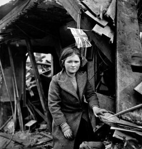 Toni Frissell - Battersea incident, England, January 1945 girl among the ruins, British flag overhead. Corresponds to V2 rocket bombing of Battersea, in London, of 27 January 1945